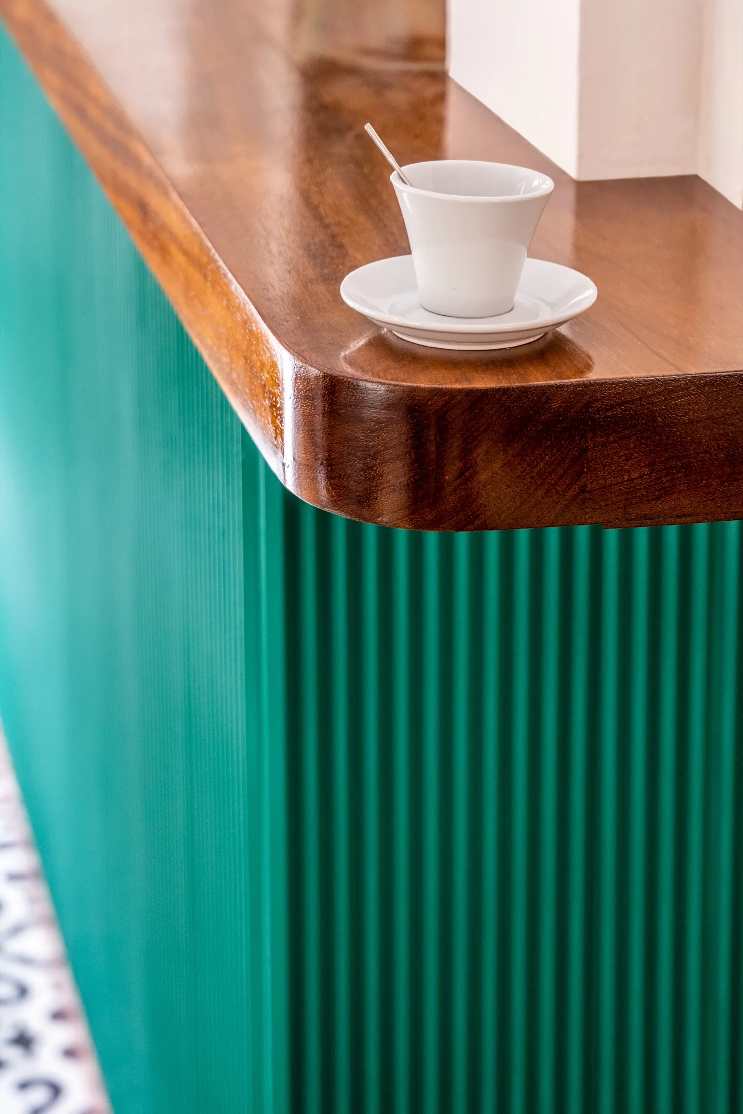 Esquina de la barra verde con encimera de madera y una taza de café